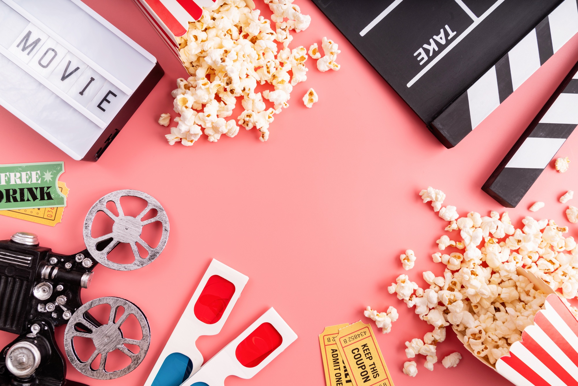 Top view of movie tools, popcorn, 3-D glasses, Cinema tickets, clapper board and light box on pink